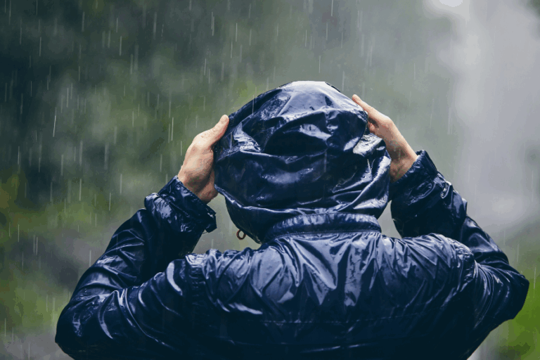 Mann im Regen mit Regenponcho
