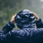 Mann im Regen mit Regenponcho